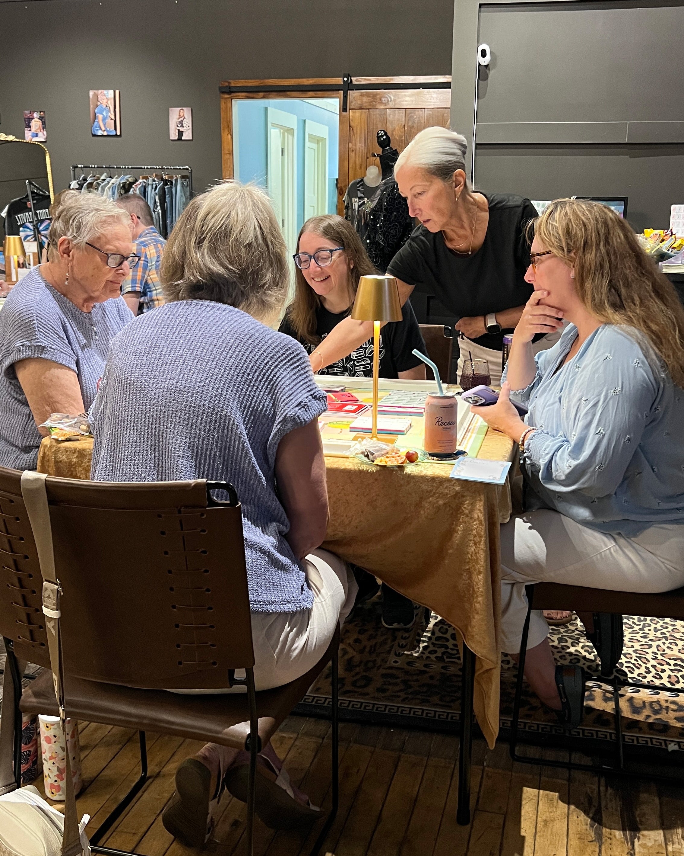 A group of women looking at tiles during a mahjong class.