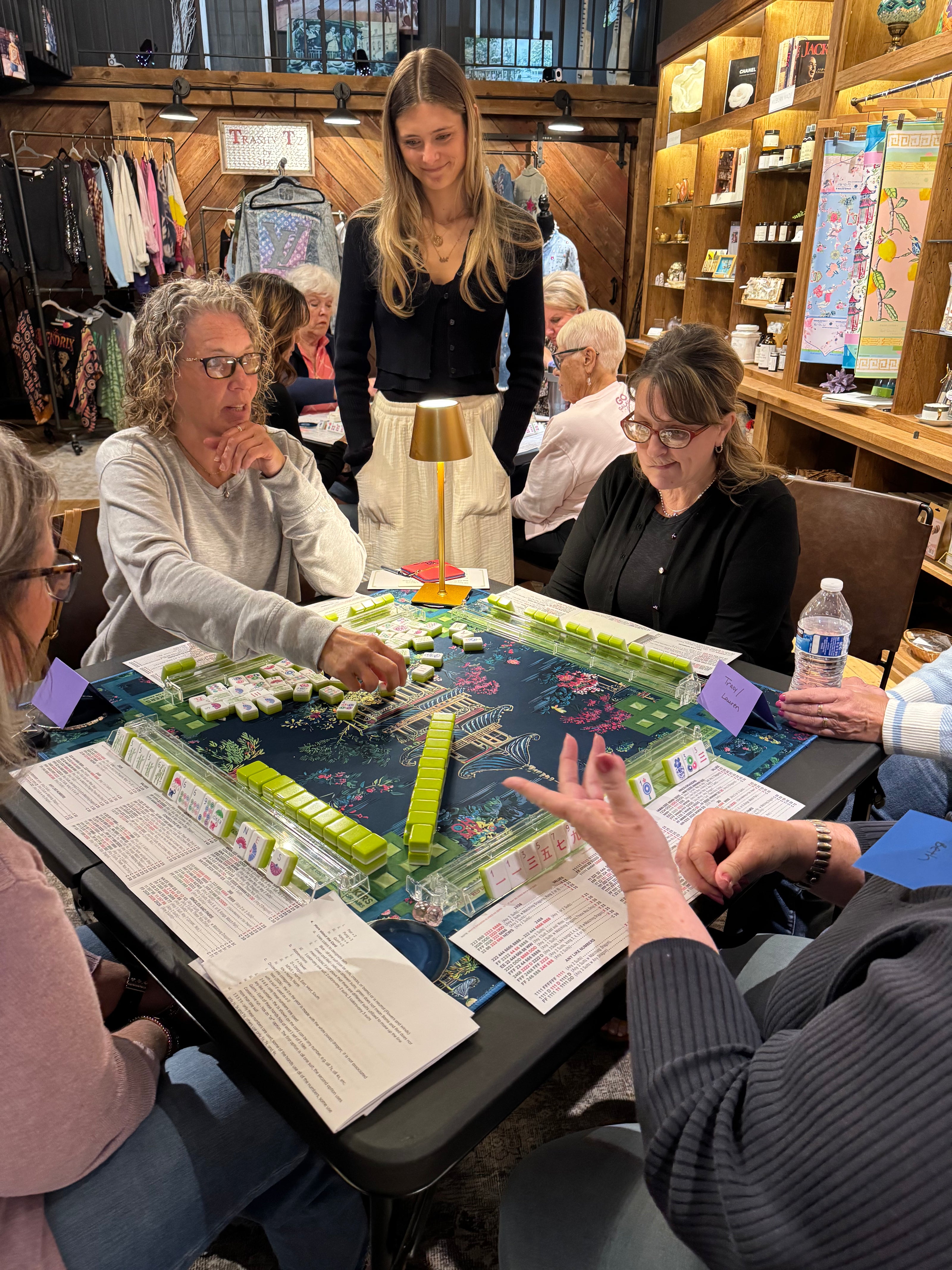 Group of people playing mahjong in a store setting